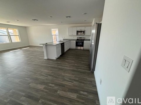 A spacious kitchen with a refrigerator, sink, and oven.