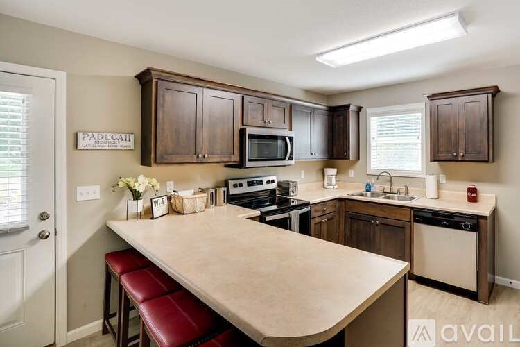 A kitchen with a table and chairs in front of it.