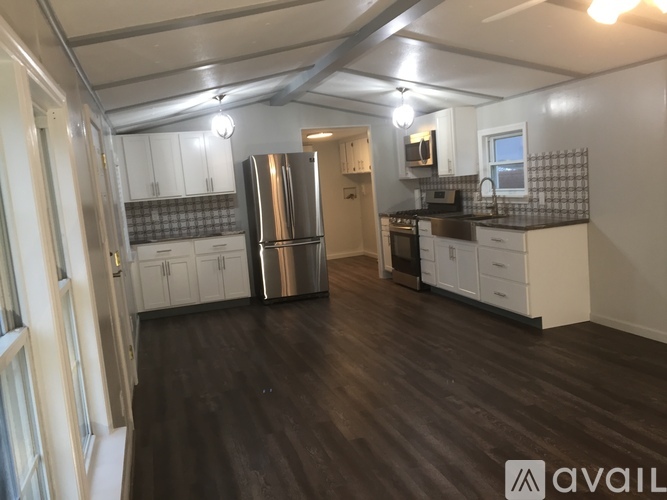 A kitchen with a refrigerator, oven, and microwave.