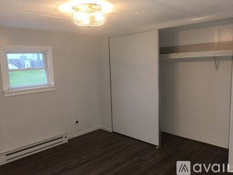 A room with a window and a wooden floor.