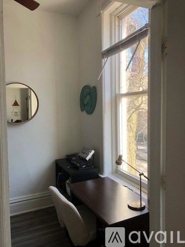 A room with a desk and a chair in front of a window.