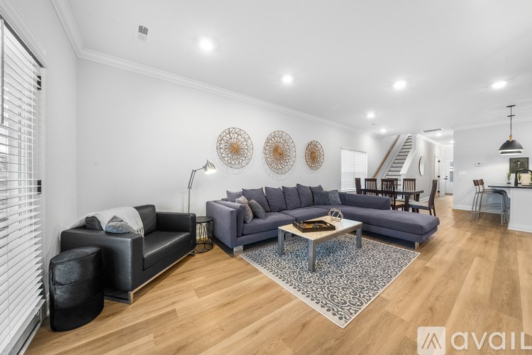 A living room with a grey sofa, a black armchair, a coffee table, and a rug.