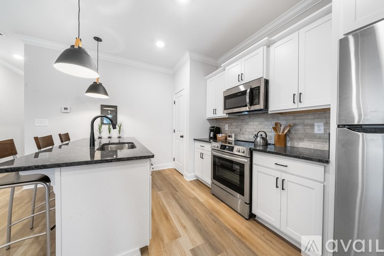 A kitchen with white cabinets and a black countertop.