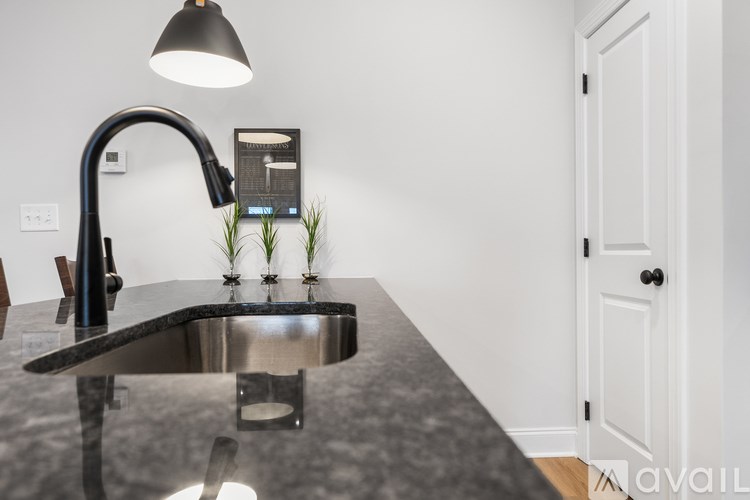 A modern kitchen with a granite countertop and a black faucet.