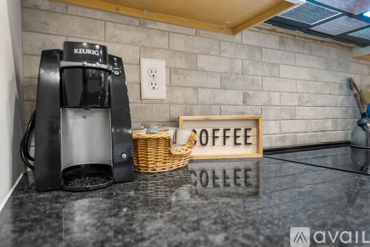 A Keurig coffee maker sits on a counter next to a sign that says "Coffee College.".