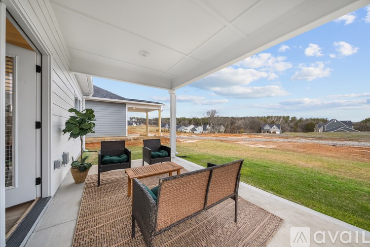 A patio with a table and chairs overlooks a grassy area.