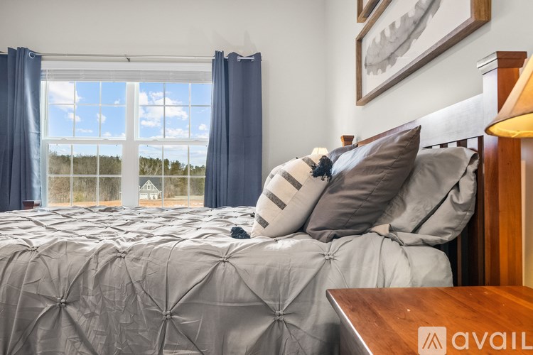 A bedroom with a large bed and a window overlooking a landscape.