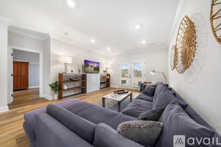 A living room with a grey sofa and a wooden floor.