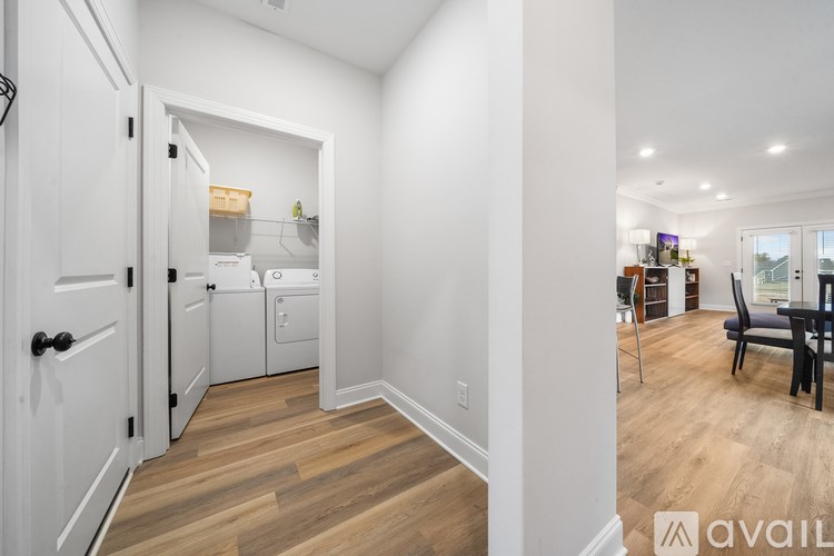 A kitchen with white cabinets and a wooden floor.
