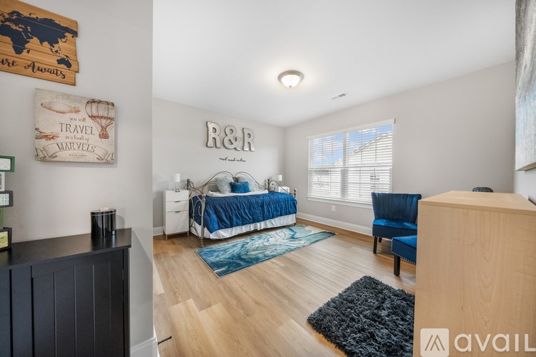 A bedroom with a bed, chair, and a wall hanging that says "Travel Marvels".