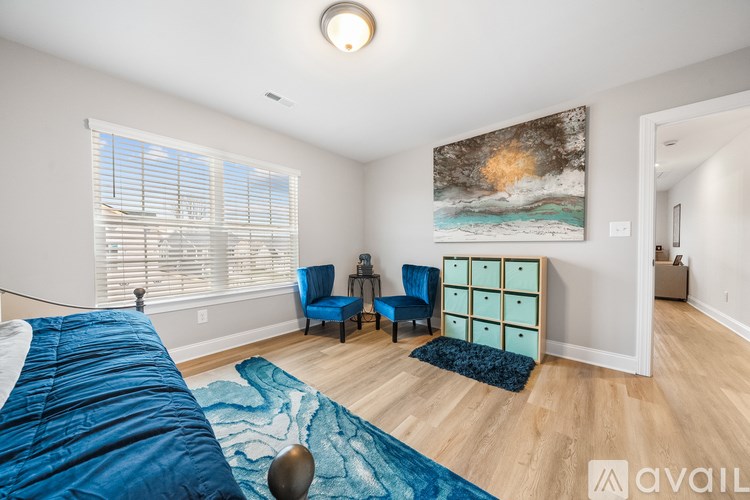 A bedroom with a large bed and a painting on the wall.