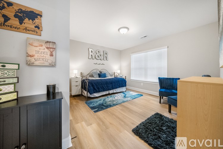 A bedroom with a bed, a chair, and a dresser.