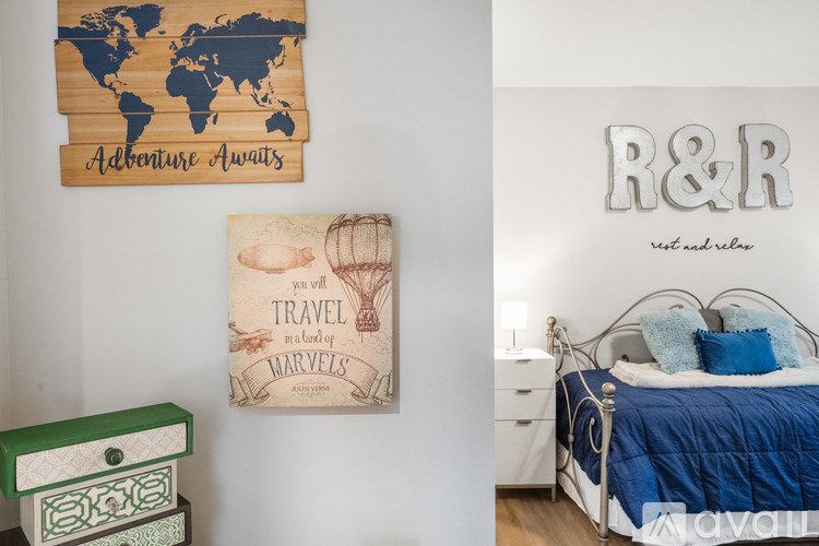 A bedroom with a world map and a poster that says "Adventure Awaits".