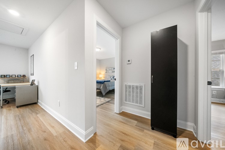 A black door is on the right side of a white wall.