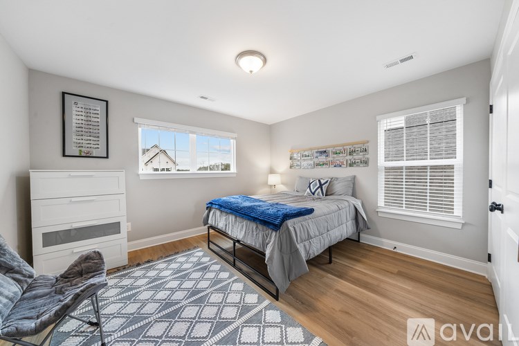A bedroom with a bed, dresser, and window.