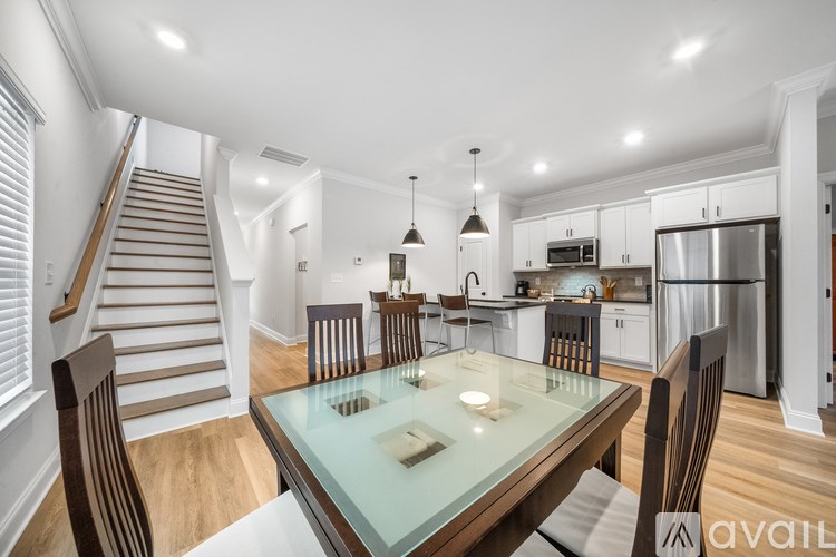 A modern kitchen with a glass dining table and chairs.