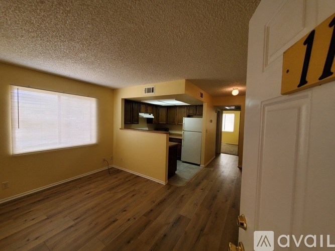 A room with wooden floors and a white door with a number 11 on it.