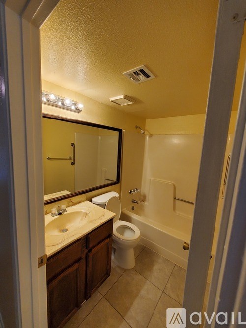 A bathroom with a toilet, sink, and mirror.
