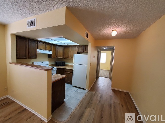 A kitchen with wooden cabinets and a white refrigerator.