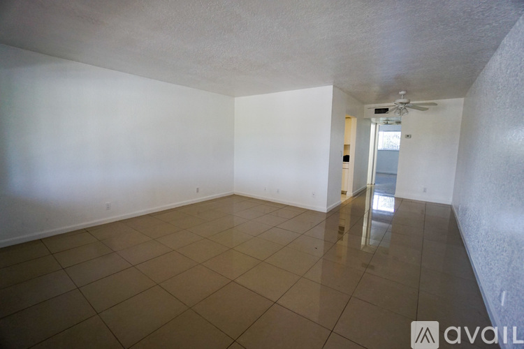 A spacious room with tiled flooring and a ceiling fan.