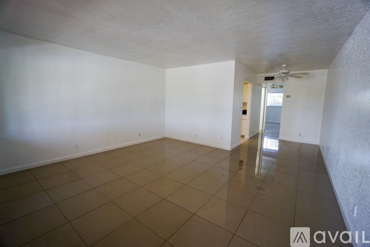 A spacious room with tiled flooring and a ceiling fan.