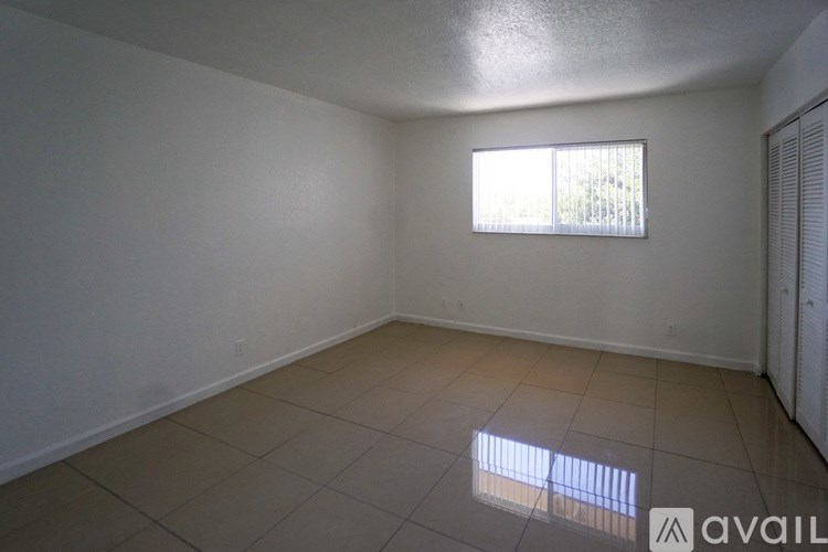A room with a window and tiled floor.