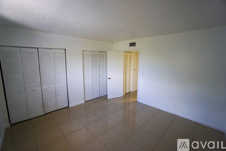 A room with a tiled floor and a door at the end.