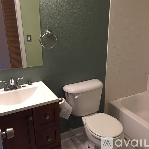 A white toilet is in a bathroom with green walls.