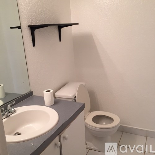 A bathroom with a toilet, sink, and toilet paper.