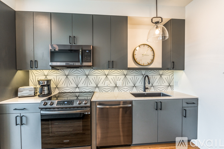 A modern kitchen with a stove top oven and a microwave above it.