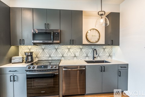 A modern kitchen with a stove top oven and a microwave above it.