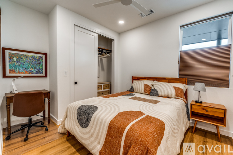 A bedroom with a bed, desk, and chair.