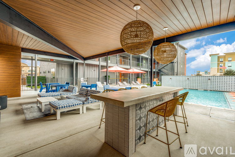 A modern outdoor lounge area with a pool and a bar.
