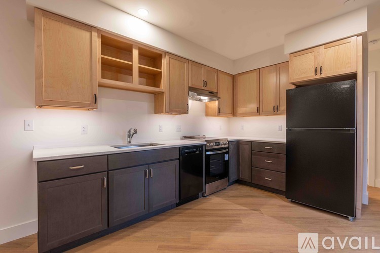 A kitchen with wooden cabinets and black appliances.