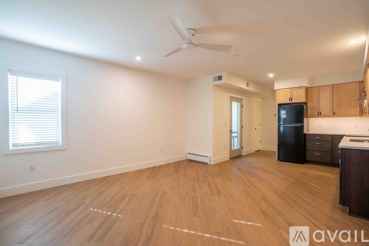 A spacious room with wooden flooring and a ceiling fan.