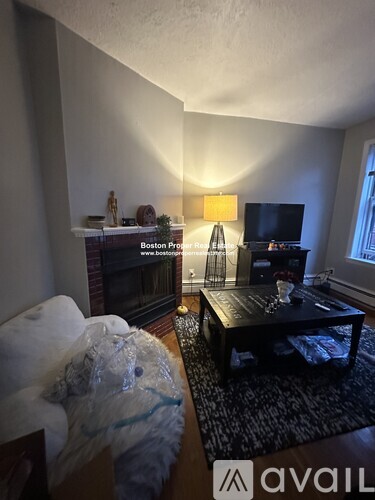 A living room with a couch, a coffee table, and a television.