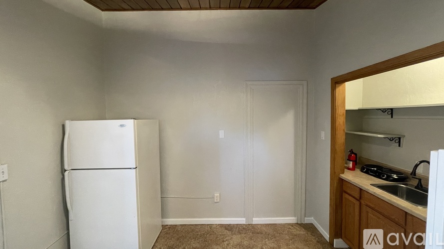 A kitchen with a white fridge and wooden cabinets.