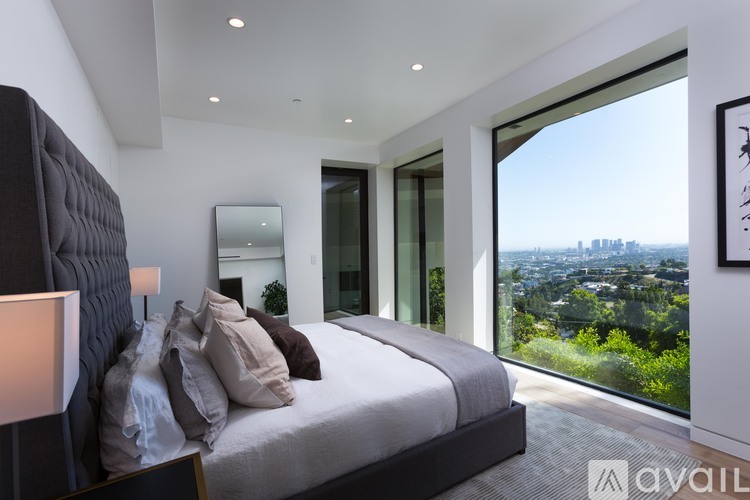 A bedroom with a large bed and a view of the city.