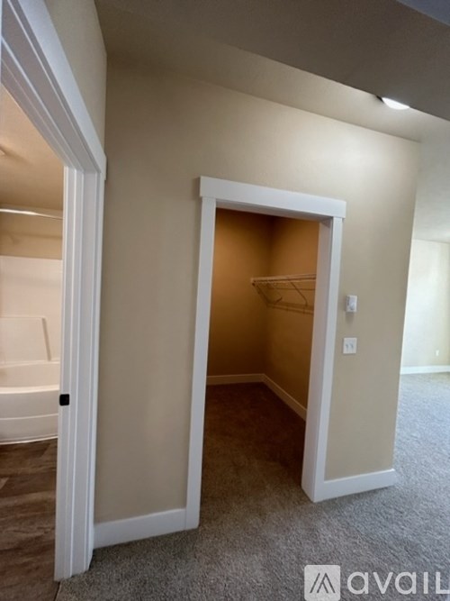 A room with a carpeted floor and a white door.