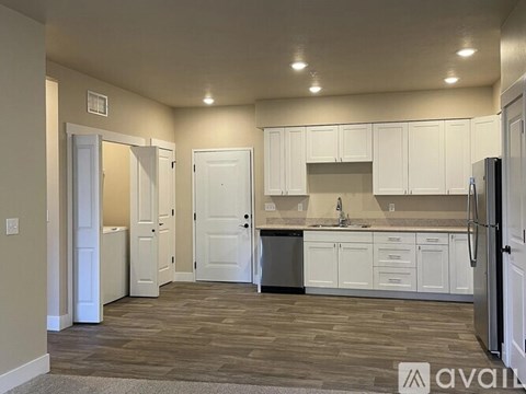 A kitchen with white cabinets and a refrigerator.