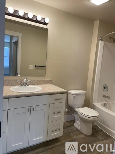 A bathroom with a sink, toilet, and bathtub.