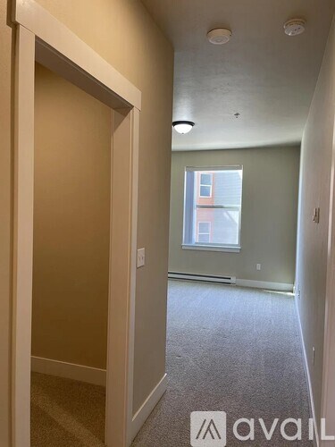 A room with a carpeted floor and a window.