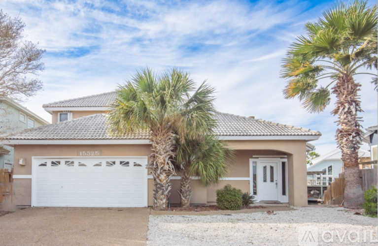 A house with a white garage door and palm trees in front.