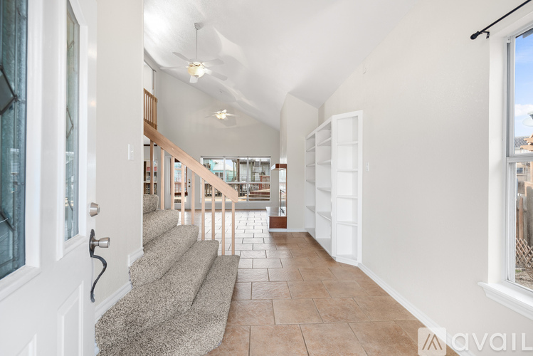 A hallway with a staircase leading to a second floor.