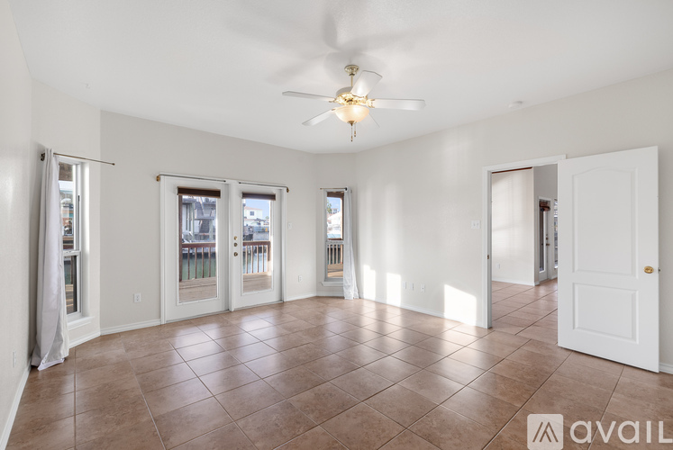 A spacious room with a ceiling fan and tiled flooring.