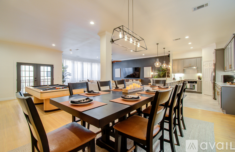 A modern dining room with a large table and chairs.