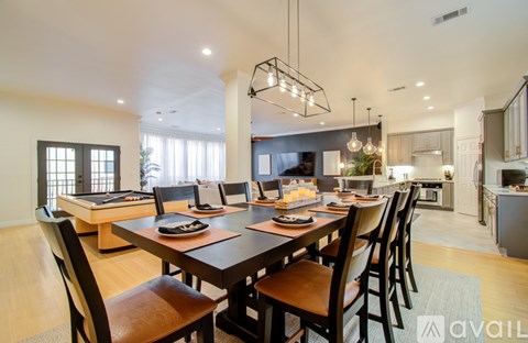 A modern dining room with a large table and chairs.