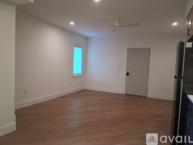 A room with wooden floors and a ceiling fan.