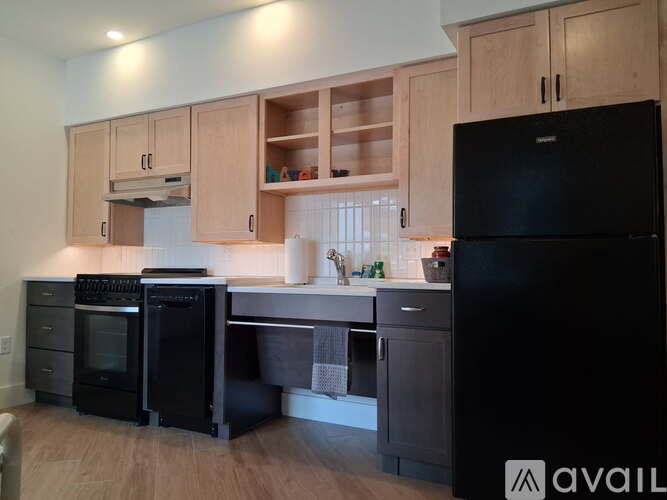 A kitchen with wooden cabinets and black appliances.