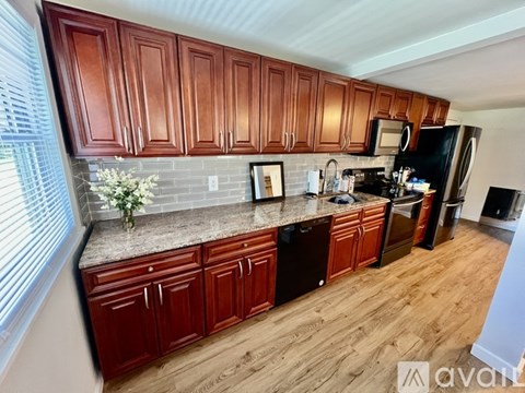 A kitchen with wooden cabinets and a granite countertop.